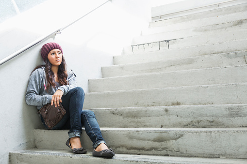 Mixed race young woman (18 years, Caucasian, Hispanic, Asian and Pacific Islander) with sad expression.