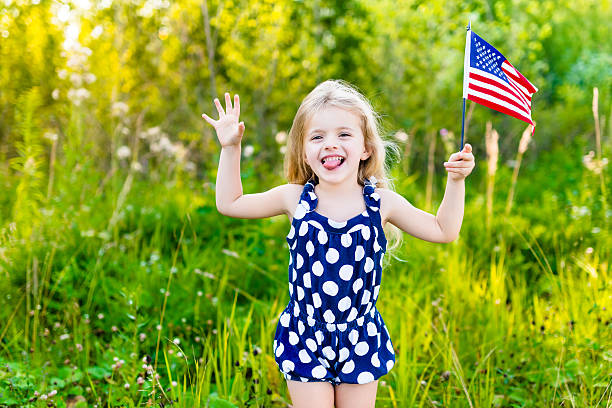 rapariga colocar para fora sua língua e a agitar bandeira americana - child flag fourth of july little girls imagens e fotografias de stock