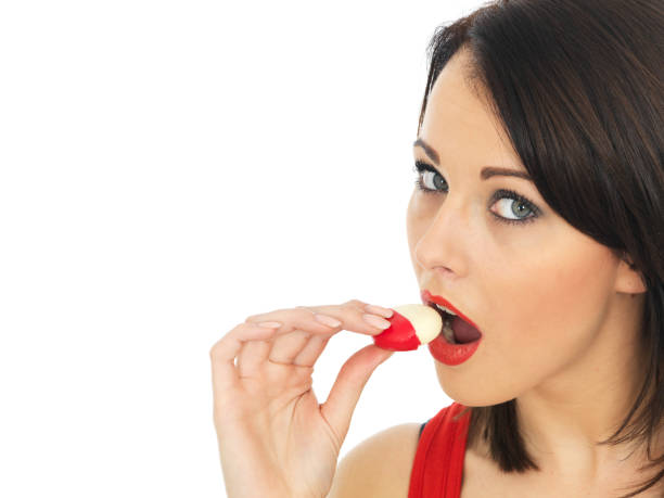 istock Young Woman Eating Mini Baby Bell Processed Cheese Round 479233284
