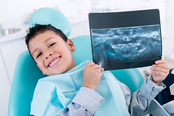 Boy with an x-ray Happy boy at the dentist holding an x-ray dental cavity photos stock pictures, royalty-free photos & images