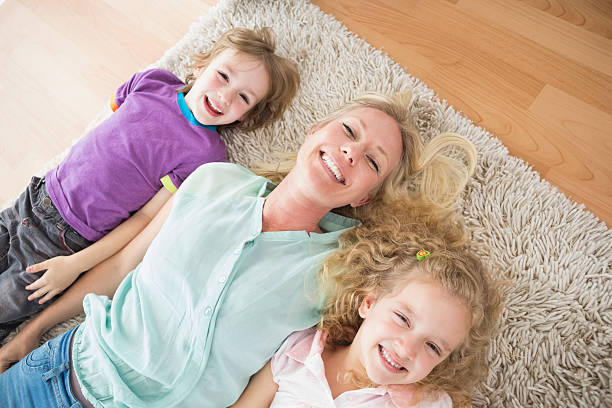 istock Happy mother and children lying on rug 479233628