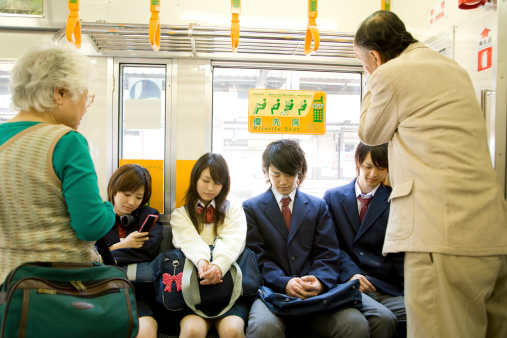 High scool student sitting on priority seat of train