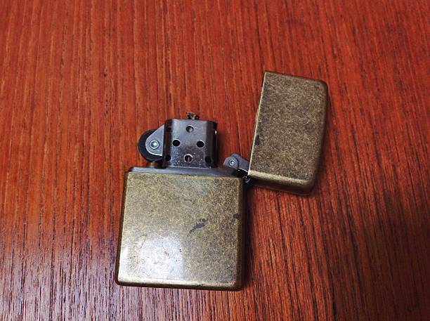 istock Zippo wind proof lighter aged brass on teak wood surface 479235696