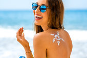 Woman using sun cream on the beach