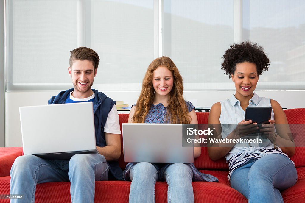 Creative team using laptops and digital tablet Creative team using laptops and digital tablet on sofa in office 18-19 Years Stock Photo