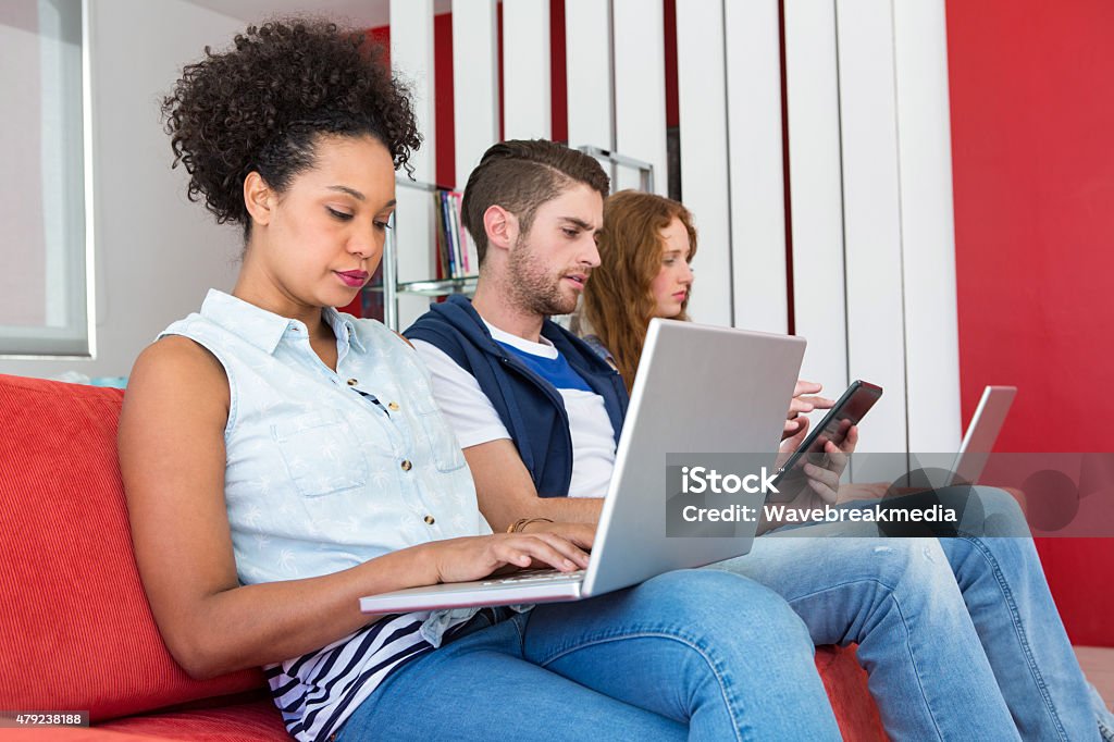 Creative team using laptops and digital tablet Creative team using laptops and digital tablet on sofa in office 18-19 Years Stock Photo