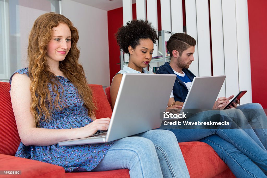 Creative team using laptops and digital tablet Creative team using laptops and digital tablet on sofa in office 18-19 Years Stock Photo