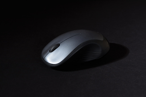 A computer mouse with finger wheel on a black table.