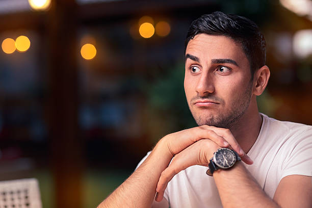 sorpreso giovane uomo seduto in un ristorante - irony foto e immagini stock