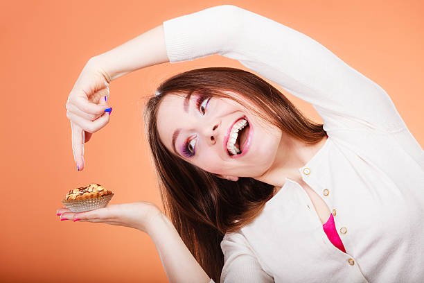 istock Smiling woman holds cake in hand pointing with finger 479244848