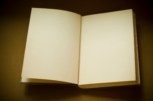 An antique vintage book open to the first page with blank pages and copy-space.