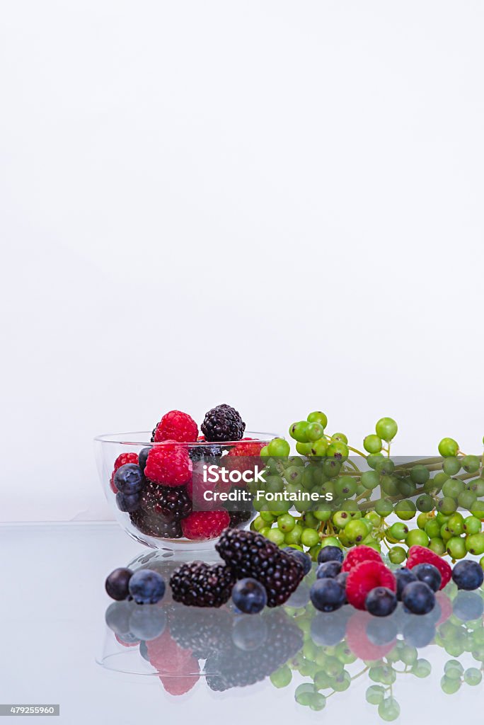 Bramble Raspberry & lueberry & blackberry in the glass bowl on the glass table with green 2015 Stock Photo