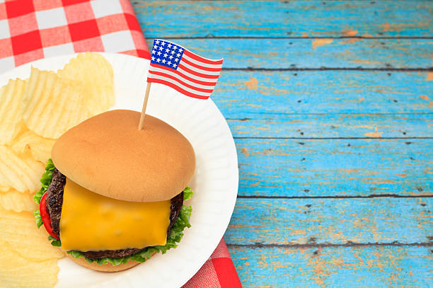 istock Cheese Burger with Patriotic US Flag on Blue Picnic Table 479256938
