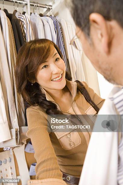 Husband And Wife Choosing Clothes Stock Photo - Download Image Now - Adult, Adults Only, Asian and Indian Ethnicities