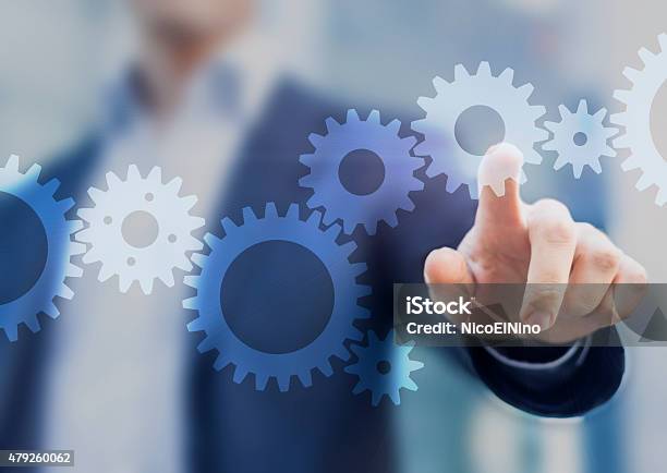 Businessman Touching Gears Stock Photo - Download Image Now - Gear - Mechanism, Connection, Motion