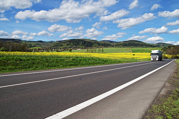 istock Truck arrives on the road between the rapeseed field 479260376