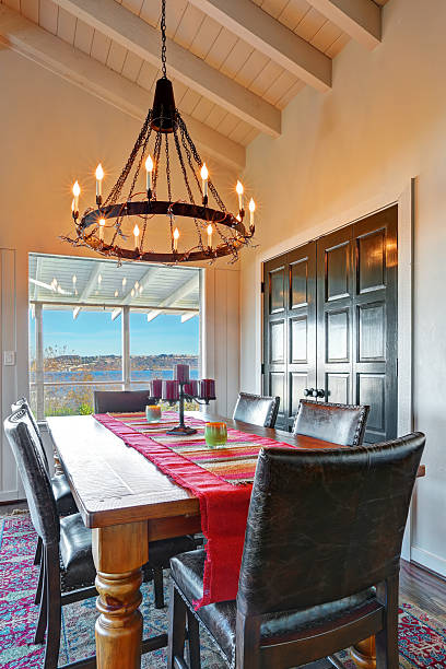 istock Dining room table with water view and antique iron chandelier. 479260438