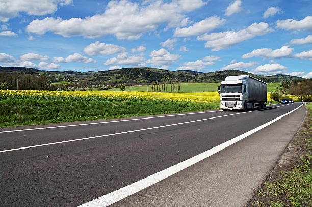 istock Truck driving on the road between rapeseed field 479260448
