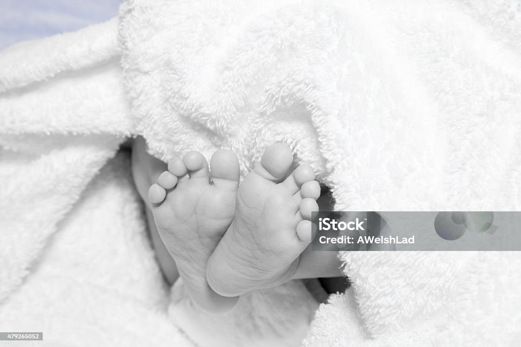 Newborn baby's feet and bottom end Newborn baby's feet and bottom end; monochrome color blend. 2015 Stock Photo