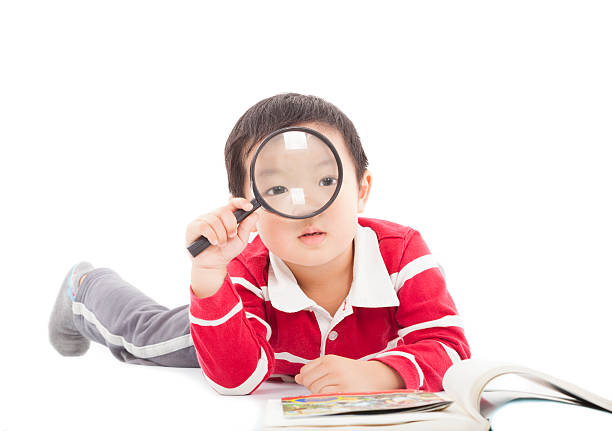 istock happy kid is holding magnifying glass to explore 479268005