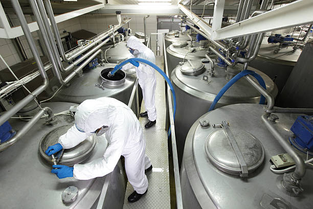 istock Two specialists in  overalls working with industrial process tanks 479268237