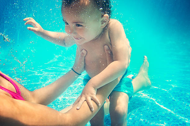little boy foto submarina de natación con madre en piscina. - swimwear bikini swimming pool red fotografías e imágenes de stock