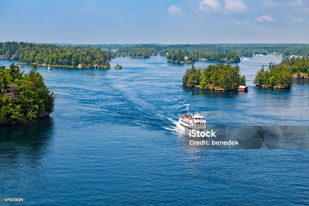 Thousand Islands Tour Boat New York State and Ontario Canada Photo taken from above of a tour boat with tourists passing between islands at Thousand Islands National Park, St Lawrence River, located between Ontario Canada and New York State USA. Thousand Islands - St. Lawrence River Stock Photo