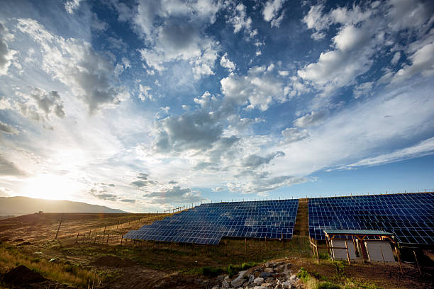 istock Solar Panels and Green Field Under Dramatic Sky at Sunset 479273222