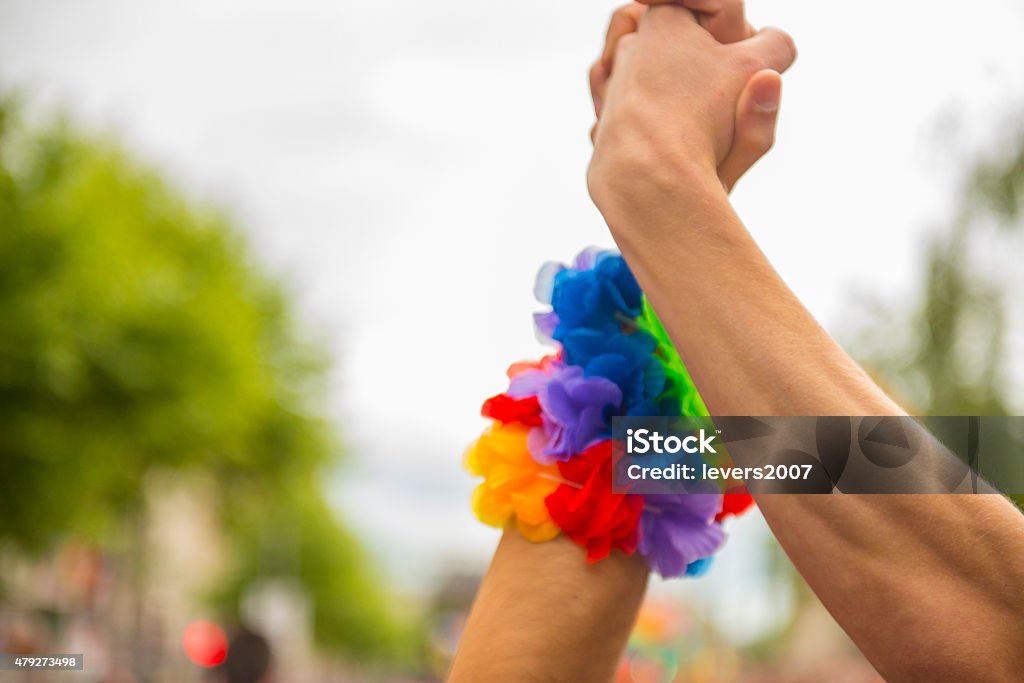 gay pride parade two homosexual men holding hands at a pride parade. LGBTQIA Pride Event Stock Photo