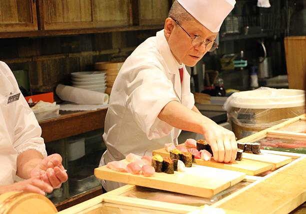 Sushi Chef at Tsukiji Tokyo,Japan, Jun 21,2015: Sushi chef preparing Sushi at Small Sushi Restaurant  Tukiji Fish Market in Tokyo Japan. japanese chef stock pictures, royalty-free photos & images
