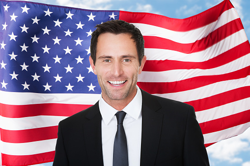 Portrait Of Happy Businessman In Front Of Usa Flag