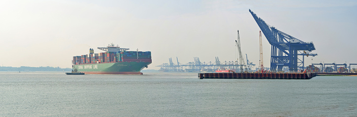Felixstowe, Suffolk, England - June 12, 2015: China Shippings Container vessel CSCL Atlantic Ocean pulling away from Felixstowe port tugs helping.