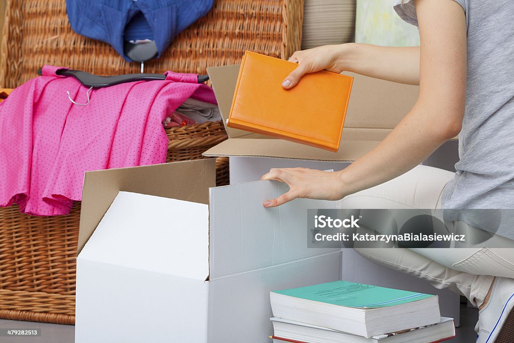 Colorful books packing A woman packing colorful books into a cradboard box Neat Stock Photo