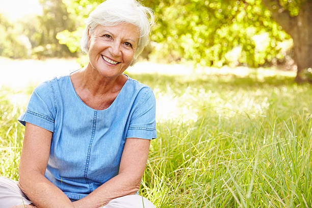 Senior woman sitting on grass relaxing