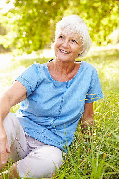 istock Senior woman sitting on grass relaxing 479288042