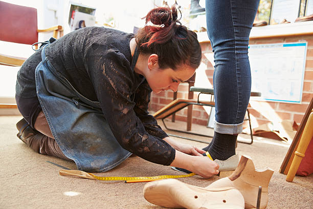 istock Young shoemaker measuring customers feet 479288106
