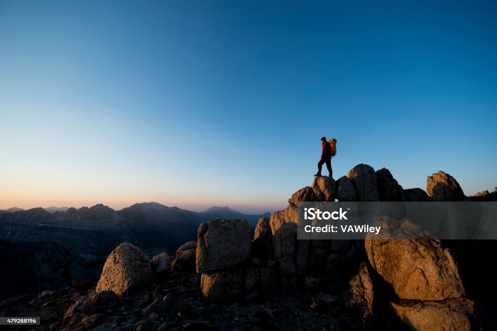 Summit at sunset Mountain climber on the summit of a peak during sunset  2015 Stock Photo