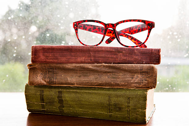 istock Reading glasses and books on rainy window 479291842