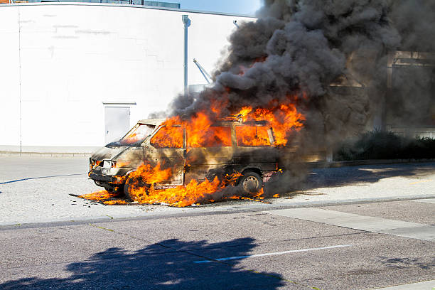 auto auf feuer - bereitschaftspolizist stock-fotos und bilder