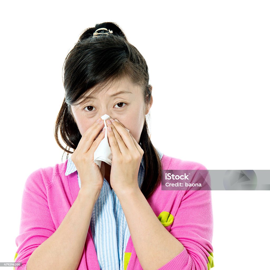 Young asian woman blowing her nose Young asian woman blowing her nose isolated on white background. 2015 Stock Photo