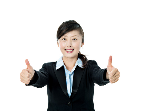Asian businesswoman with thumbs up against white background.