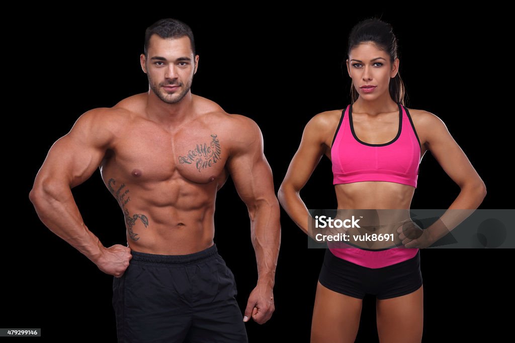 Attractive couple Attractive muscular couple posing in front of black background 20-29 Years Stock Photo