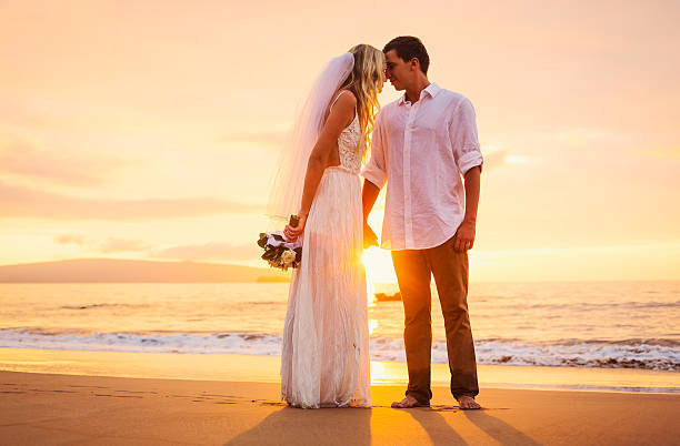 istock bride and groom on beach at sunset 479299352