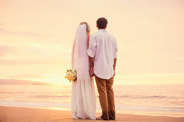 istock bride and groom on beach at sunset 479299360