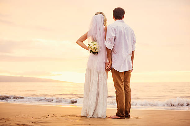 istock bride and groom on beach at sunset 479299362