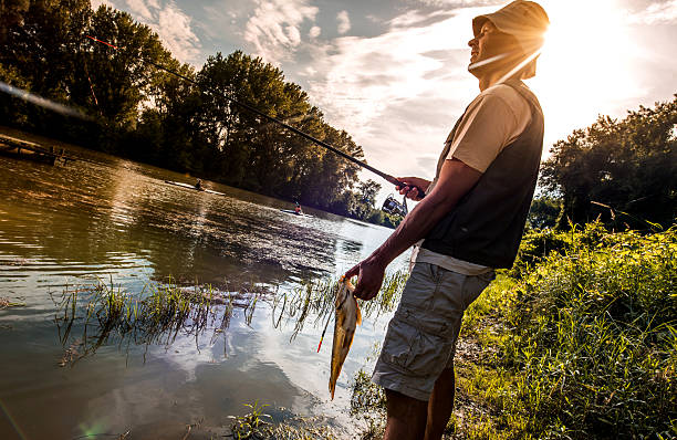 istock Happy fisherman caught a fish on the river. 479299574