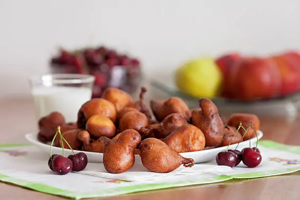 Photo of Freshly baked donuts for breakfast with cherries, glass of milk