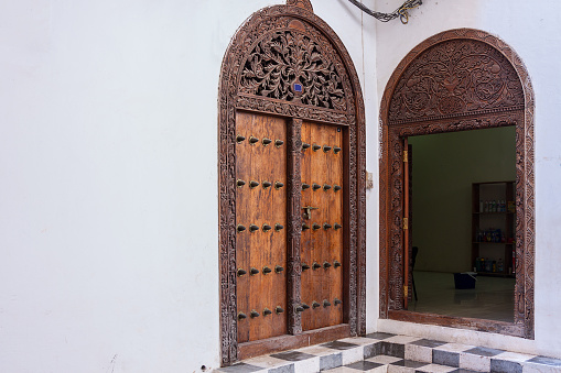 traditional arabic zanzibari doorway ornately carved showing the interior and exterior of this entrance.