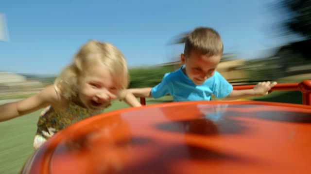 HD: Two Kids Having Fun On Playground Wheel