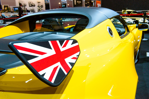 Amsterdam, The Netherlands - April 16, 2015: Lotus Elise 220 Cup race car rear wing deatil on display during the 2015 Amsterdam motor show. People in the background are looking at the cars.
